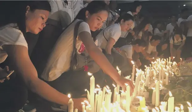  ?? PICTURE: TODD PITMAN/AP ?? 0 Mourners in the Philippine capital, Manila, light candles and lay flowers in front of a memorial to the 38 people killed in the casino attack