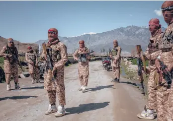  ?? HUYLEBROEK/THE NEW YORK TIMES JIM ?? Members of the Taliban’s elite “Red Unit” wear white high-top sneakers with green-and-yellow trim in Laghman, Afghanista­n. Called Cheetahs, the shoes have been favored by insurgents for decades.