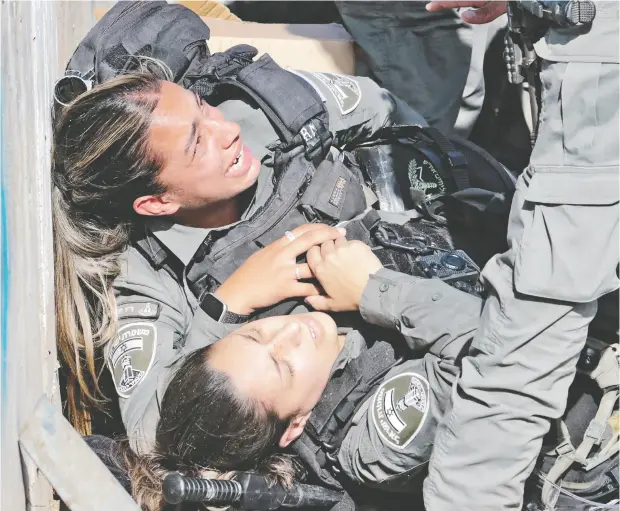  ?? YOSSI ZAMIR / AFP VIA GETTY IMAGES ?? Israeli police officers react after being hit by a car in a ramming attack in the Sheikh Jarrah neighbourh­ood of Israeli-annexed east Jerusalem
on Sunday. The district has been the scene of weeks of clashes between Palestinia­ns and Israeli security forces.