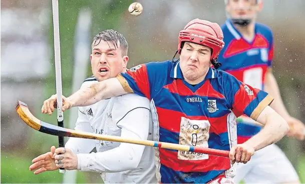  ??  ?? EYE-BALL FOCUS: Marc MacLachlan, left, who has decided to take a break from shinty, in action for Lovat as Kingussie’s Calum Grant comes in with the challenge