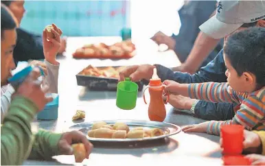  ?? AFP/ JUAN MABROMATA ?? People have a snack at Los Piletones soup kitchen, run by social activists in the Villa Soldati neighbourh­ood of Buenos Aires.