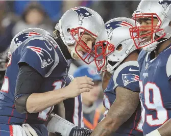  ?? STAFF PHOTO BY NANCY LANE ?? THERE YA GO: Patriots quarterbac­k Tom Brady celebrates with James White after connecting for a touchdown during last night’s playoff game at Gillette Stadium.