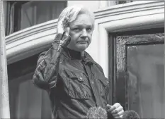  ?? AP PHOTO ?? In this May 19, 2017, photo, WikiLeaks founder Julian Assange greets supporters from a balcony of the Ecuadorian embassy in London. The Justice Department inadverten­tly named Assange in a court filing in an unrelated case that raised immediate questions about whether the WikiLeaks founder had been charged under seal. Assange’s name appears twice in an August 2018 filing from a prosecutor in Virginia in a separate case involving a man accused of coercing a minor.