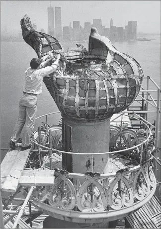  ?? KEITH MEYERS / THE NEW YORK TIMES FILE (1984) ?? A worker stands on scaffoldin­g in 1984 during preparatio­ns to remove the Statue of Liberty’s torch. After decades in the pedestal of the Statue of Liberty, the original torch will see the elements again in its new home.