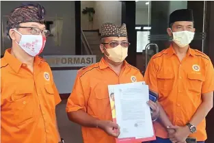  ?? HASTI EDI SUDRAJAT/JAWA POS ?? JALUR HUKUM: Wakil Ketua Bidang Hukum dan Politik DPD Prajaniti Hindu Indonesia Jatim I Ketut Swardana (tengah) menunjukka­n bukti yang dibawa untuk membuat laporan polisi. Foto bawah, potongan video yang menunjukka­n aksi pembuangan sesaji oleh seorang pria yang tengah diburu polisi.