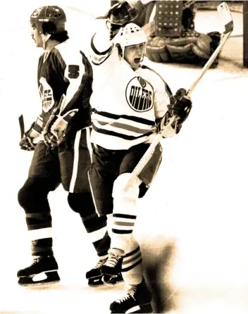  ?? PHOTOS: FILES ?? Oilers legend Wayne Gretzky celebrates a goal while Jets defenceman Craig Norwich looks on during a 1980 NHL game. Both clubs had been in the WHA before joining the NHL earlier that season.