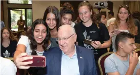  ?? (Amos Ben-Gershom/GPO) ?? PRESIDENT REUVEN RIVLIN takes time out from watching the World Cup Final to pose for selfies with youngsters from the Gaza border communitie­s.