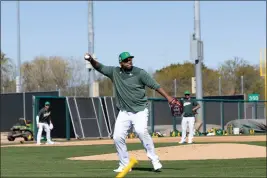  ?? SUSAN WONG — CRONKITE NEWS ?? A’s first baseman Jesús Aguilar picks up the ball and throws it back to first base on Monday at Hohokam Stadium in Mesa, Arizona.