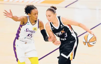  ?? CHRISTIAN PETERSEN/GETTY ?? The Mercury’s Diana Taurasi handles the ball against the Sparks’ Brittney Sykes during a game June 27 at Phoenix Suns Arena. The former Uconn star has been voted by Courant readers as the top former Husky in the WNBA.