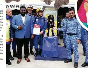  ?? ?? At the signing of a memorandum of understand­ing between the Malaysian Civil Defence Force and Search and Rescue (SAR) Dogs Malaysia, to present an award of appreciati­on on behalf of Persatuan Haiwan Terbiar Malaysia.