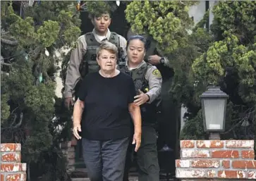  ?? Genaro Molina Los Angeles Times ?? L.A. COUNTY sheriff’s deputies escort county Supervisor Sheila Kuehl from her Santa Monica house after serving her a search warrant Wednesday. The search was tied to a probe into Peace Over Violence, a nonprofit.