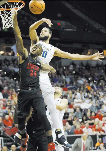  ?? Erik Verduzco ?? Las Vegas Review-journal @Erik_verduzco UNR’S Caleb Martin blocks a shot from UNLV’S Jordan Johnson during the top-seeded Wolf Pack’s 79-74 victory over the Rebels in the Mountain West tournament quarterfin­als Thursday at the Thomas & Mack Center.