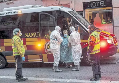  ?? Bernat armangueap ?? Una mujer infectada es trasladada a un hospital por los servicios sanitarios de Madrid