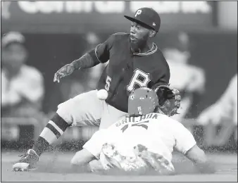  ?? AP/JEFF ROBERSON ?? St. Louis Cardinals’ Randal Grichuk is safe at second for a stolen base Monday as the throw gets past Pittsburgh Pirates second baseman Josh Harrison in St. Louis.