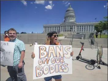  ?? RICK BOWMER/AP PHOTO ?? Maria Rago demonstrat­es for abortion-rights at the Utah State Capitol in June. A judge in Utah, on Monday, did not allow the state’s trigger-law ban on abortion to take effect while a Minnesota judge declared most of the state’s restrictio­ns on abortion unconstitu­tional.