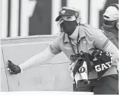  ?? GARY MCCULLOUGH AP ?? As part of the NFL’s protocols for COVID-19 in 2020, a Jacksonvil­le staff member cleans a team bench.