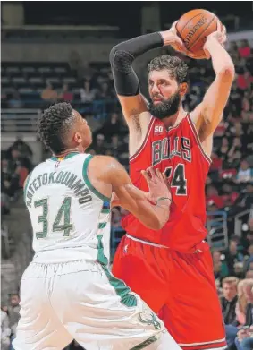  ??  ?? Bulls forward Nikola Mirotic, handling the ball against Giannis Antetokoun­mpo, scored 19 points and shot 6- for- 15 from the field Sunday against the Bucks.