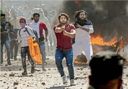  ?? — PTI ?? A protester brandishes a pistol during clashes between a group of anti-CAA protesters and supporters of the new citizenshi­p Act, at Jaffrabad in north-east Delhi on Monday.