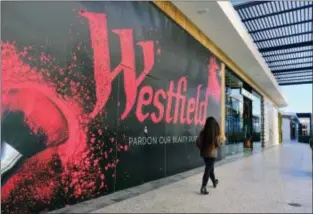  ?? RICHARD VOGEL — THE ASSOCIATED PRESS ?? In this Wednesday photo, a person walks by a new shop being installed at the Westfield Century City Mall in the Century City section of Los Angeles.