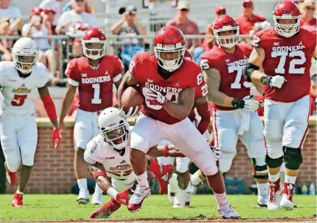  ?? [AP PHOTO] ?? OU receiver Lee Morris avoids a tackle by Florida Atlantic’s Korel Smith during Saturday’s blowout victory in Norman. Morris, a former walk-on, was given a scholarshi­p after his big performanc­e.