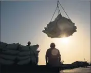  ?? AFP/Getty Images ?? CHINA’S Ministry of Commerce said Trump’s latest threat was tantamount to “extreme pressure and blackmail.” Above, bags of soybeans at a Chinese port.