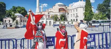  ?? Agence France-presse ?? Women with Turkish national flags gather outside the Hagia Sophia in Istanbul on Friday.