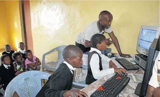  ?? Pictures: GARY HORLOR ?? KEEN PUPILS: Simpiwe Xatasi teaches the children of his village basic computer skills on two salvaged PCs