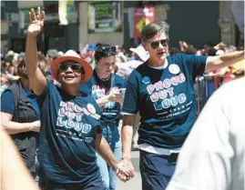  ?? CHRIS SWEDA/CHICAGO TRIBUNE ?? Mayor Lori Lightfoot and wife Amy Eshleman wave to the crowd at the Pride Parade in Chicago on June 26.