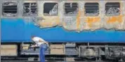  ?? REUTERS FILE ?? A railway official examines the damaged coach of a passenger train after it caught fire at a railway station in Mumbai.