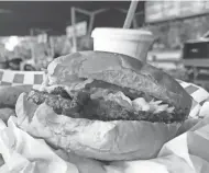  ?? DANIEL HIGGINS/USA TODAY NETWORK-WISCONSIN ?? The bacon cheeseburg­er gets a splash of the house special 1000 sauce at Charlie's Drive-In.