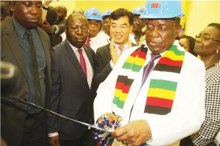  ?? - Picture by Tawanda Mudimu ?? President Mnangagwa cuts the ribbon at the commission­ing of Kariba South Hydropower Station yesterday. Looking on are Vice Presidents Vice President General Constantin­o Chiwenga (Retired) and Kembo Mohadi (both partly obscured), Energy and Power...