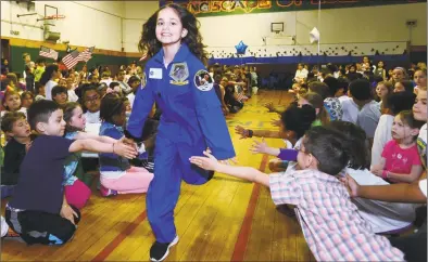  ?? Erik Trautmann / Hearst Connecticu­t Media ?? Valeria Atunes is greeted by students during Columbus Magnet School’s annual Young Astronauts Mission Landing event Friday at the school in Norwalk. The landing ceremony for their 2019 mission mimicked the two Apollo moon landing missions, 11 and 12.