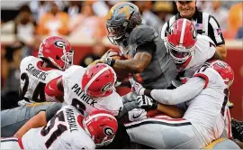  ?? CURTIS COMPTON / CCOMPTON@AJC.COM ?? Georgia defenders led by Lorenzo Carter (top right) tackle Tennessee running back John Kelly at the line of scrimmage for no gain.