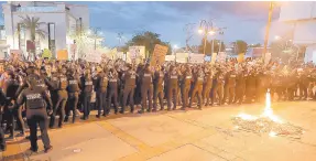  ?? ?? l Agentes de Policía resguardan las instalacio­nes del Poder de Justicia de Sonora, luego que manifestan­tes iniciaran con quema de pancartas.