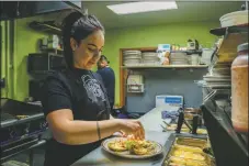  ?? ?? Left: Yumira Cerecedes, a line cook at Casa de Valdez prepares a dish on Monday (Nov. 15). Cerecedes starting working at the restaurant as a dishwasher after high school. After seven years, ‘it’s like my second family, you know?’ said Cerecedes. ‘Because they believe in me.’ Right: Patrons
enjoy dinner at Casa de Valdez on Monday (Nov. 15) before the restaurant closed its doors the following week.