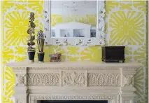  ??  ?? Susan Nelson and Todd Martz styled this mantel in a family room. The bold wallpaper called for a simple object to hang above the fireplace; the accessorie­s were chosen for their childlike qualities.