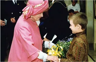  ?? ?? FLOWER POWER: Neil Woods, son of the Lord Mayor of Hull, Councillor Dennis Woods, presents a posy to the Queen Mother inside the Ferens Art Gallery.