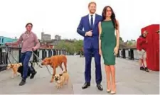  ?? — AFP ?? A pedestrian walks dogs past waxwork figures of Britain’s Prince Harry and his US fiance Meghan Markle, during a photo opportunit­y arranged by Madame Tussauds, near Windsor Castle in Windsor, west of London yesterday, as preparatio­ns continue ahead of...