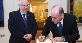  ?? (Haim Zach/GPO) ?? PRESIDENT REUVEN RIVLIN watches as Jordanian Ambassador Ghassan Majali, who was previously the Hashemite kingdom’s envoy to Spain, signs the registry at the President’s Residence on November 8.