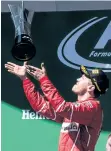  ?? WENN ?? Ferrari driver Sebastian Vettel tosses the trophy in the air while celebratin­g his victory at the Brazilian GP on Sunday at Interlagos in Sao Paulo, Brazil.