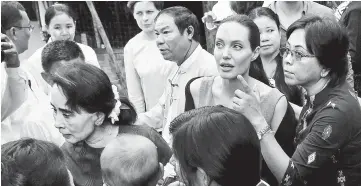  ??  ?? Suu Kyi (left) and UNHCR special envoy Angelina Jolie arrive at a hostel for female factory workers in the Hlaingtary­ar Industrial Zone in Yangon on Aug 1, 2015. — Reuters file photo