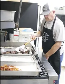  ?? Brodie Johnson • Times-Herald ?? It takes a lot of work and a lot of volunteers to make the Forrest City Kiwanis Club’s Pancake Day successful. Scottie Deere fries sausage and bacon to go with the pancakes that Kiwanians began serving this morning at the First Baptist Church on Rosser Street. Pancakes will be served until 7 this evening.