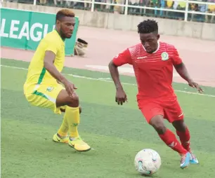  ??  ?? Joshua Agboola (right) of Katsina tries to outwit Orji Kalu of Kano Pillars during their league match in the ongoing Nigeria Profession­al Football League