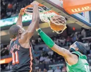  ?? LYNNE SLADKY/ASSOCIATED PRESS ?? Miami’s Dion Waiters, left, slams home a dunk in the face of Boston’s Kyrie Irving during the Heat’s victory over the Celtics on Wednesday night.