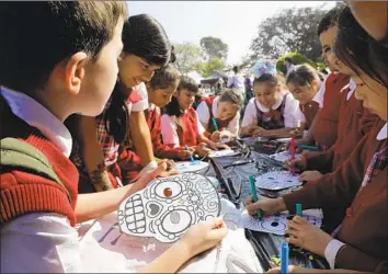  ?? Photograph­s by Irfan Khan Los Angeles Times ?? STUDENTS from St. Anthony School in San Gabriel color face masks this week at Calvary Cemetery in East Los Angeles. The Archdioces­e of Los Angeles held the Dia de los Muertos workshop for the fifth year.