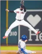  ?? The Associated Press ?? Ryan Goins of the Toronto Blue Jays slides under a high through that Deven Marrero of the Boston Red Sox had to leap for during sixth-inning AL action in Boston on Monday.