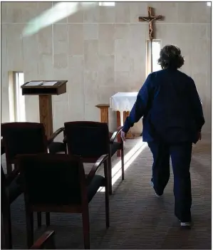  ?? (AP/Jae C. Hong) ?? Chaplain Nancy Many visits a chapel after offering Communion to a covid-19 patient at Providence Holy Cross Medical Center in the Mission Hills section of Los Angeles on Jan. 15. As families are barred from visiting loved ones to curb the disease’s spread, chaplains often are there to act as surrogates, holding the hands of the dying, praying with them and carrying iPads into hospital rooms to provide a real-time connection with grieving families.
