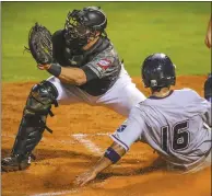  ?? Arkansas Democrat-Gazette/STEPHEN B. THORNTON ?? Naturals' Carlos Garcia slides safely into home ahead of the tag from Travelers catcher Wade Wass to score the go-ahead run in the seventh inning Wednesday at Dickey-Stephens Park in North Little Rock.