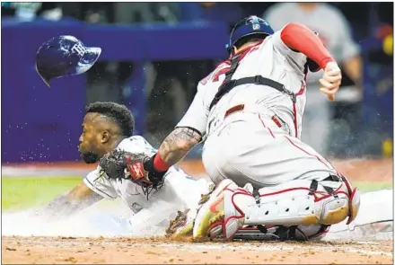  ?? Chris O'Meara Associated Press ?? TAMPA BAY’S Randy Arozarena steals home in the seventh inning past Boston Red Sox catcher Christian Vazquez in series opener.