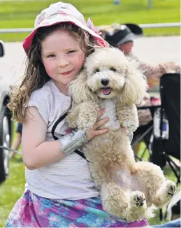  ?? PHOTOS: GERARD O’BRIEN ?? Family day . . . Georgie Jakeway (5), of Dunedin, and dog Rosie enjoy a picnic at a family reunion during the Tuapeka Harness Racing Club’s annual race meeting, at Forbury Park, yesterday.